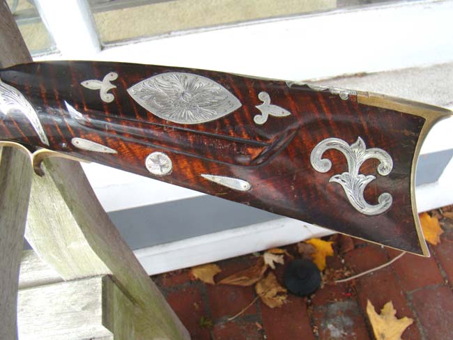 A fine silver inlaid curly maple Pennsylvania percussion long rifle by Joseph Douglass of Huntington county circa 1850-1860.